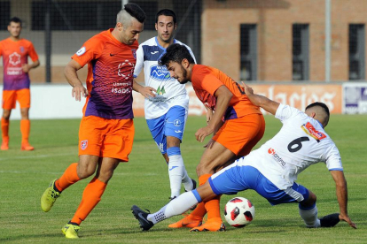 Torres y Manchado pugnan por un balón con un jugador del Almazán-Santi Otero