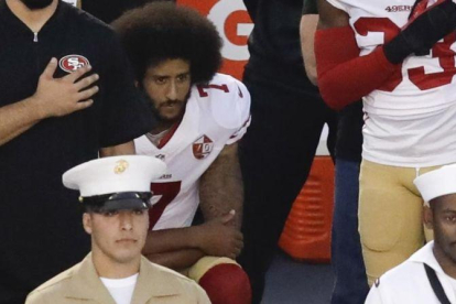 Colin Kaepernick se niega a levantarse y pone la rodilla en tierra durante el himno de EEUU, este viernes en un partido de pretemporada.-AP / CHRIS CARLSON