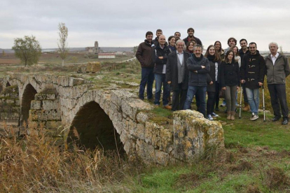 El grupo de alumnos posa en el puente de Trisla junto a la calzada romana, acompañados por el alcalde (centro).-ECB