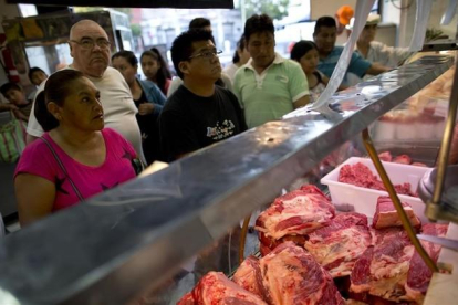 Unos clientes compran carne de vacuno en un mercado de Buenos Aires.-AP / NATACHA PISARENKO