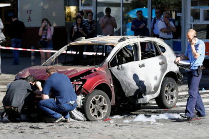 Agentes inspeccionan el coche en el que viajaba el periodista Pavel Sheremet, este miércoles en Kiev.-REUTERS / VALENTYN OGIRENKO