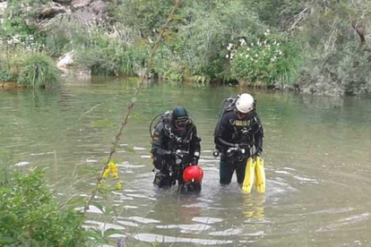 Dos efectivos del GEAS de la Guardia Civil inspeccionan el río con el objetivo de localizar el cuerpo del joven.-GUARDIA CIVIL