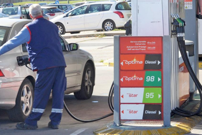 Un operario echa combustible en el depósito de un vehículo.-ISRAEL L. MURILLO