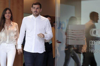Iker Casillas, en el momento de abandonar el hospital acompañado de su mujer, la periodista Sara Carbonero.-AP / LUIS VIEIRA