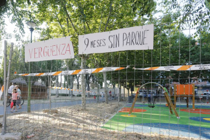 Estado actual del parque infantil con los carteles en primer plano.-RAÚL G. OCHOA