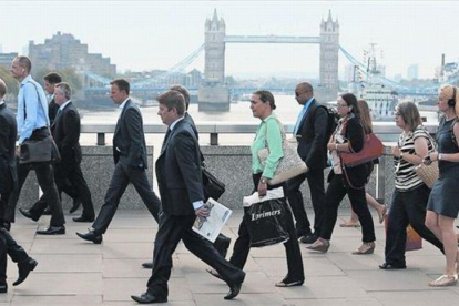 Empleados de la City londinense atraviesan el puente de Londres para dirigirse al trabajo, el pasado agosto.-REUTERS / LUKE MCGREGOR