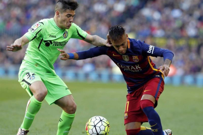 El delantero brasileño del FC Barcelona Neymar da Silva (d) pelea un balón con el defensa del Getafe Emiliano Buendía.-EFE