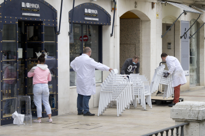 Los propietarios de un establecimiento recogen su terraza. ISRAEL L. MURILLO