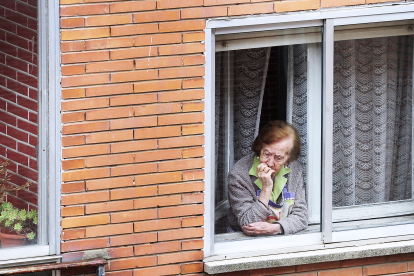 Una anciana se asoma a la ventana de su casa durante estos días de confinamiento. ISRAEL L. MURILLO