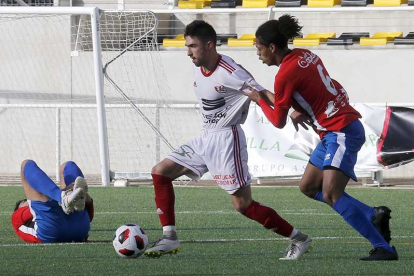 David trata de zafarse del agarrón del centrocampista del Sporting Uxama Helder-Raúl G. Ochoa