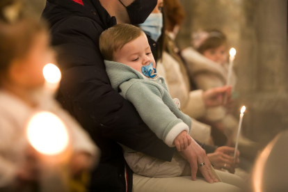 Un niño recostado sobre su padre durante la Misa de la Luz. TOMÁS ALONSO.