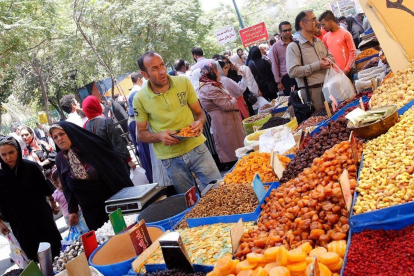 Ciudadanos iranís compran en los negocios del Gran Bazar de Teherán este lunes, horas antes de la entrada en vigor de las nuevas sanciones de EEUU. /-EFE / ABEDIN TAHERKENAREH