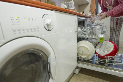 Una persona coloca vasos en el lavavajillas de la cocina de su vivienda.-ISRAEL L. MURILLO