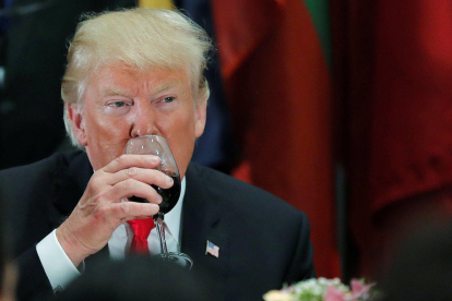 El presidente de Estados Unidos, Donald Trump, bebe de su copa durante una cena en la ONU.-CARLOS BARRIA (REUTERS)