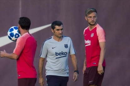 Valverde junto a Messi y Rakitic en el entrenamiento de este lunes.-JORDI COTRINA