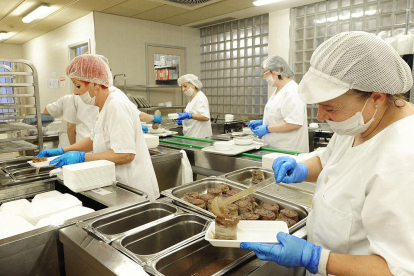 Los trabajadores de las cocinas del HUBU emplataron ayer los menús para los más de 450 pacientes.-ISRAEL L. MURILLO