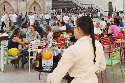 Una camarera se dispone a servir las mesas de terraza de un bar de la capital burgalesa.-ISRAEL L. MURILLO
