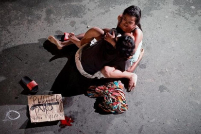 Jennelyn Olaires, de 26 años, abraza a su esposo Michael Siaron, de 30, abatido el sábado 23 de julio en Manila por civiles sin identificar.-REUTERS / CZAR DANCEL