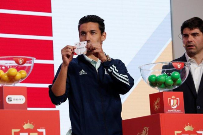 El futbolista internacional del Sevilla Jesús Navas muestra el nombre de un equipo en el último sorteo de la Copa del Rey.-EFE