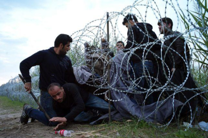 Refugiados sirios entran en Hungría por debajo de la valla de la frontera húngara-AGENCIAS