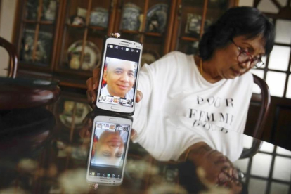La hermana del piloto del avión de Malaysia desaparecido muestra una fotografía de su hermano.-AP / JOSHUA PAUL