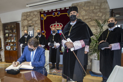 El presidente de la Junta firma en el libro de la UBU, flanqueado por los rectores de Castilla y León. ISRAEL L. MURILLO