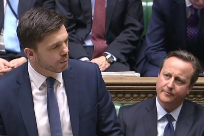 Cameron (derecha) escucha al secretario de Estado de Trabajo y Pensiones, Stephen Crabb, en la Cámara de los Comunes, en Londres, este lunes.-