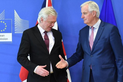 Michel Barnier tiende la mano a David Davis en la sede de la Comisión Europea, en Bruselas.-AFP