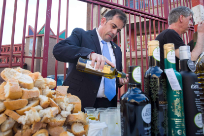 El alcalde de Cabra del Santo Cristo, Francisco Javier Justicia, prepara el aceite de su pueblo para la degustación en la barriada Juan XXIII. TOMÁS ALONSO