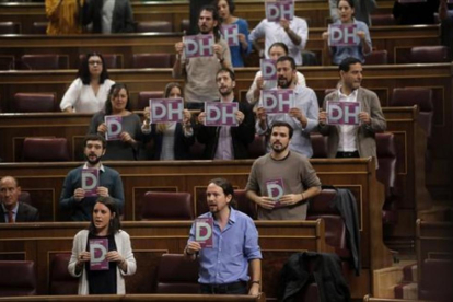 Los diputados de Podemos con octavillas, ayer.-