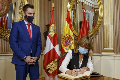 La ministra de Educación, Pilar Alegría, firma en el libro de honor del Ayuntamiento de Burgos. SANTI OTERO