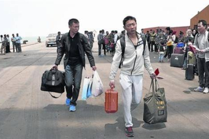 Ciudadanos chinos se preparan para embarcar en una fragata de la Armada china en Al Hudayda (Yemen).-Foto: EFE/ STR