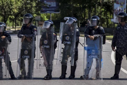 Integrantes del Cuerpo de Policía Nacional Bolivariana (CPNB) vigilan en una calle durante una manifestación de apoyo a un grupo de militares sublevados, el 6 de agosto.-EFE