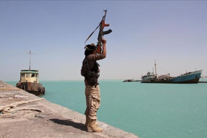 Un militar de las fuerzas gubernamentales respaldadas por Arabia Saudí levanta su arma frente al Mar Rojo, dominado por el otro lado por los huties.-/ SALEH AL OBEIDI (AFP)