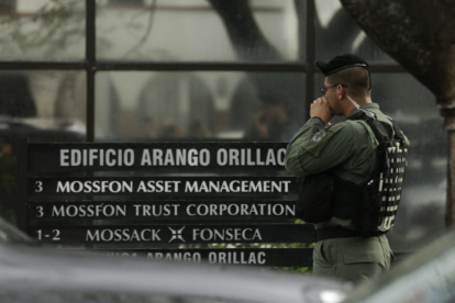 Un policía espera en la puerta de la sede de Mossack Fonseca en Ciudad de Panamá, este martes.-AP / AMULFO FRANCI