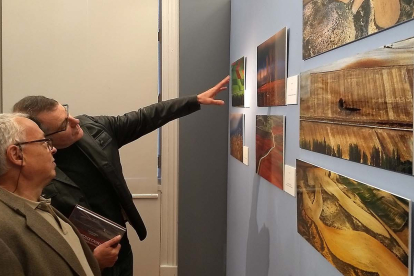 El fotógrafo sorianoCésar Sanz explica a Gonzalo Santonja imágenes de la exposición. ECB