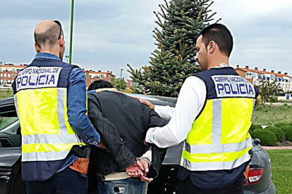 Dos agentes introducen a uno de los detenidos en un coche.-ECB