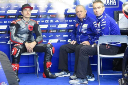 Maverick Viñales, sentado en la silla de Jorge Lorenzo en el box de Yamaha, junto a Ramon Forcada y Davide Marelli, técnico y telemétrico del mallorquín durante 9 años.-EMILIO PÉREZ DE ROZAS