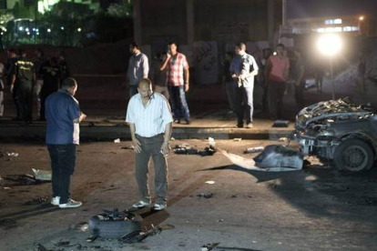 Oficiales de seguridad inspeccionan los restos de un coche bomba que estalló este martes en un distrito de Guiza, vecina de El Cairo.-Foto:   EFE / MOHAMED HESHAM