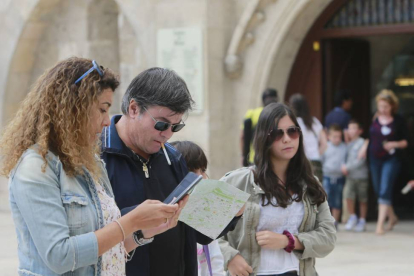 Una familia de turistas contempla el plano de la ciudad junto a la Catedral de Burgos.-RAÚL G. OCHOA