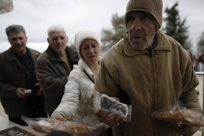 Ciudadanos griegos hacen cola para recibir alimentos con motivo de la celebración del 'Lunes Limpio', este lunes en Atenas.-Foto:   EFE / YANNIS KOLESIDIS