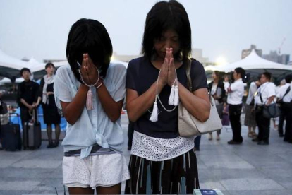 Una madre y una hija oran en la ceremonia celebrada en el Parque Memorial de la Paz.-Foto: REUTERS / TORU HANAI