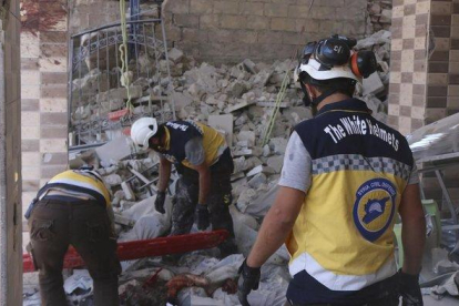 Trabajadores buscan víctimas debajo de los escombros de un edificio destruido que fue golpeado por el gobierno sirio y ataques aéreos rusos en la ciudad norteña de Maaret al-Numan en la provincia de Idlib, Siria, el lunes 22 de julio de 2019.-