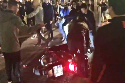Unos manifestantes tiran a un motorista que no ha querido bajarse de la moto y pretendía continuar su paso, en el paseo de Gracia con la calle Valencia, este miércoles.-GUILLEM SÀNCHEZ