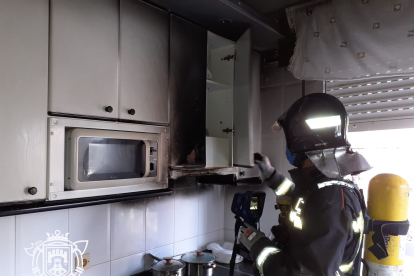 Un bombero de Burgos comprueba la temperatura de los muebles incendiados en una cocina. BOMBEROS