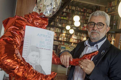 José Luis del Río coge la mano del maniquí que sujeta un ejemplar del libro y que, con distinta vestimenta, ha llamado la atención en Luz y Vida.-Santi Otero