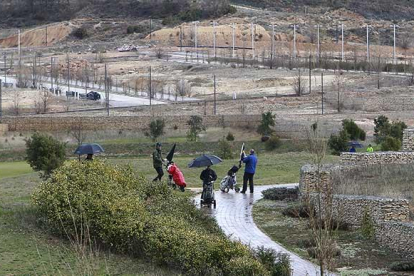 Varios jugadores practicando ayer el golf en el campo de Saldaña. De fondo se aprecia la urbanización de las parcelas de este sector, que está aún sin pagar y por rematar.-RAÚL OCHOA