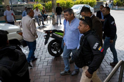 Momento en que funcionarios policiales detienen al exministro venezolano de Interior Miguel Rodriguez Torres, en el centro de la imagen con camisa azul.-EFE / MIGUEL GUTIÉRREZ