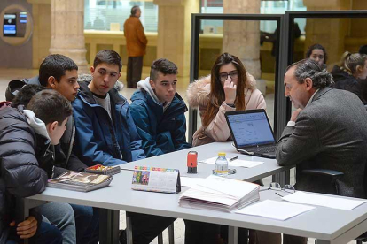 Los escolares representantes de una de las cooperativas atienden a uno de los empleados de la entidad.-R. ORDÓÑEZ