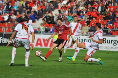 Pedro Martín pasa el balón rodeado de jugadores delRayo en el partido de la primera vuelta disputado en Anduva.-ALFONSO G. MARDONES